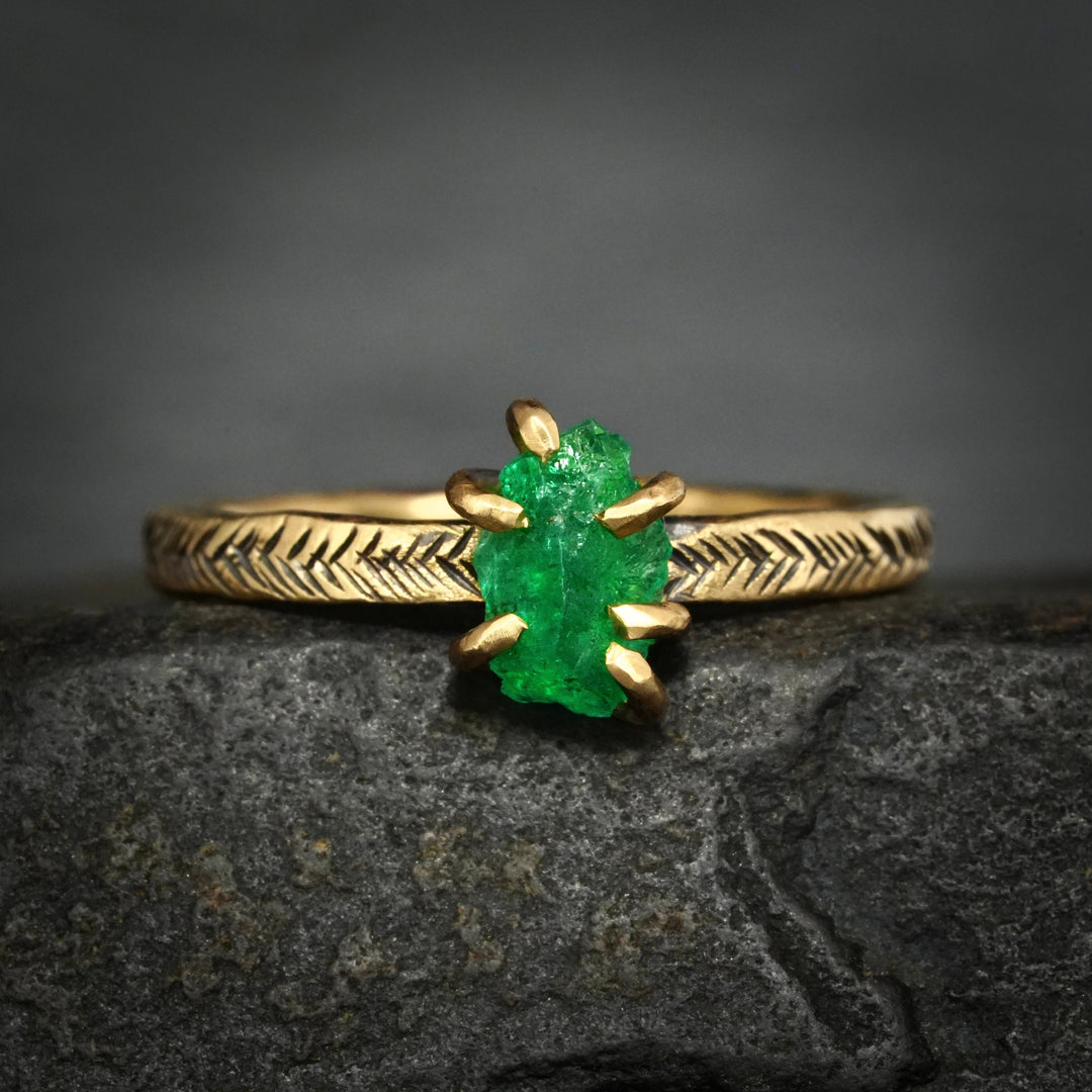 Yellow gold viking engagement ring with a bright green emerald