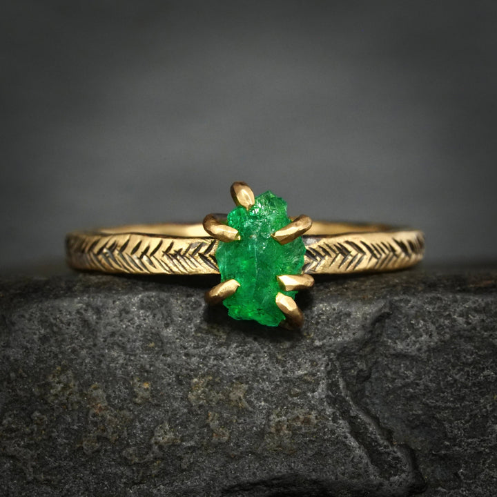 Yellow gold viking engagement ring with a bright green emerald